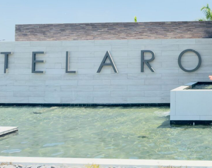 Realtor Dash Hernandez at the entrance of Telaro at Tradition, a 55+ community in Port St. Lucie, FL